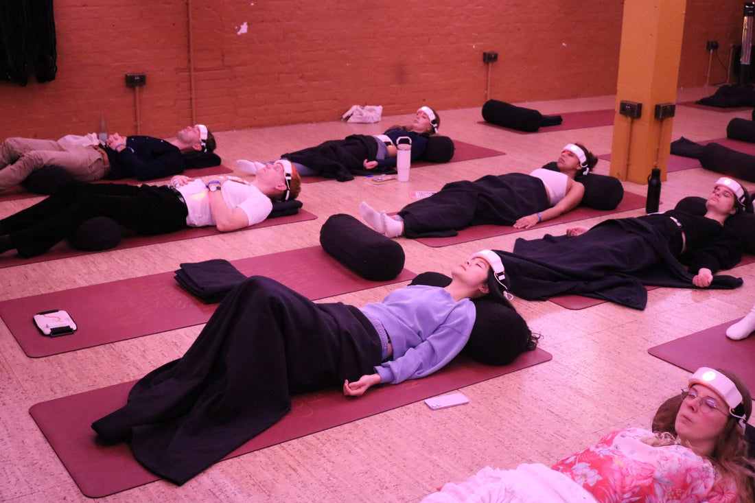 Women lying down doing red light therapy and breathwork