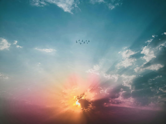 Sunshine breaking through the clouds with birds soaring
