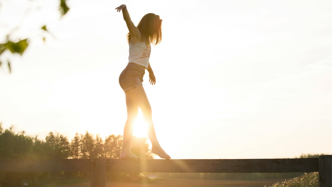 Women in nature balancing on a wooden plank