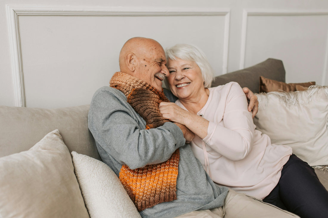 Healthy aging a couple cuddling on the couch 
