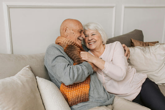 Healthy aging a couple cuddling on the couch 